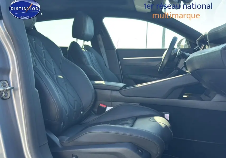 Vue intérieure côté gauche montrant les sièges avant en cuir noir et l'accoudoir central d'une Peugeot 508 SW gris artense.