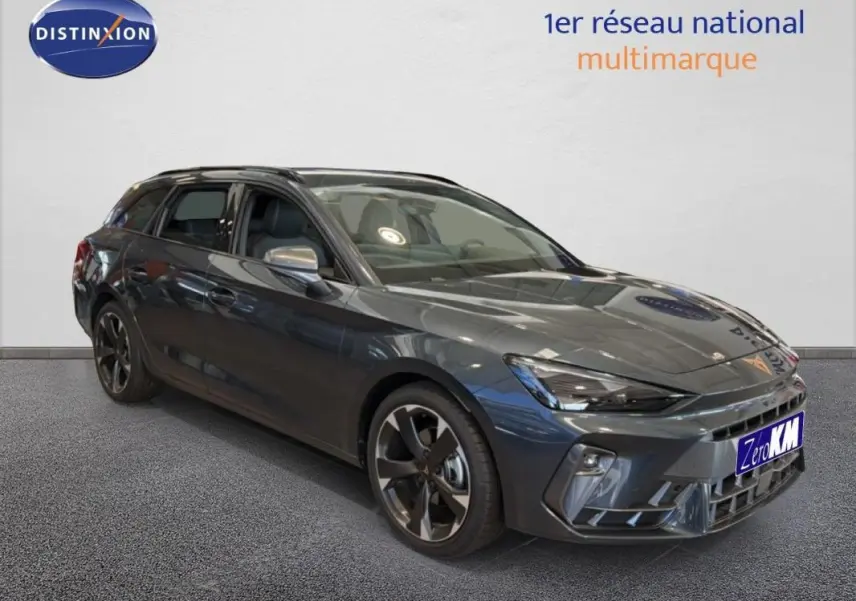 Vue 3/4 avant d'une CUPRA Leon ST gris métallisé avec barres de toit et jantes aluminium distinctives.