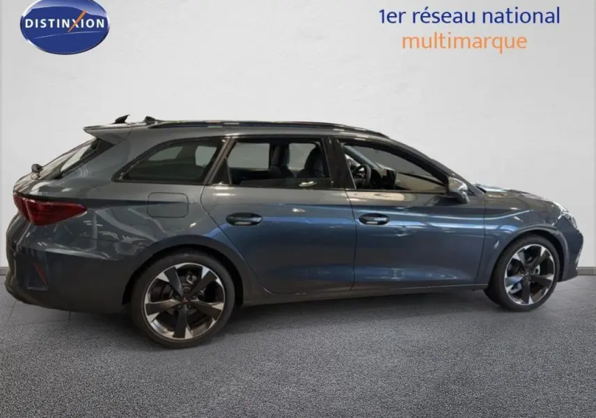 Profil droit d'une CUPRA Leon ST gris métallisé avec barres de toit et jantes aluminium distinctives.