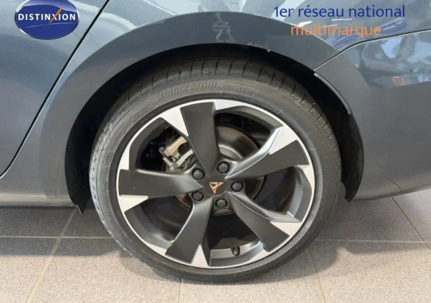 Gros plan sur la roue arrière droite d'une CUPRA Leon gris 2025 avec jante aluminium bicolore et logo CUPRA central.