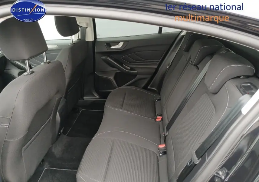 Vue intérieure côté droit montrant la banquette arrière en tissu noir avec appuie-têtes et ceintures de sécurité.