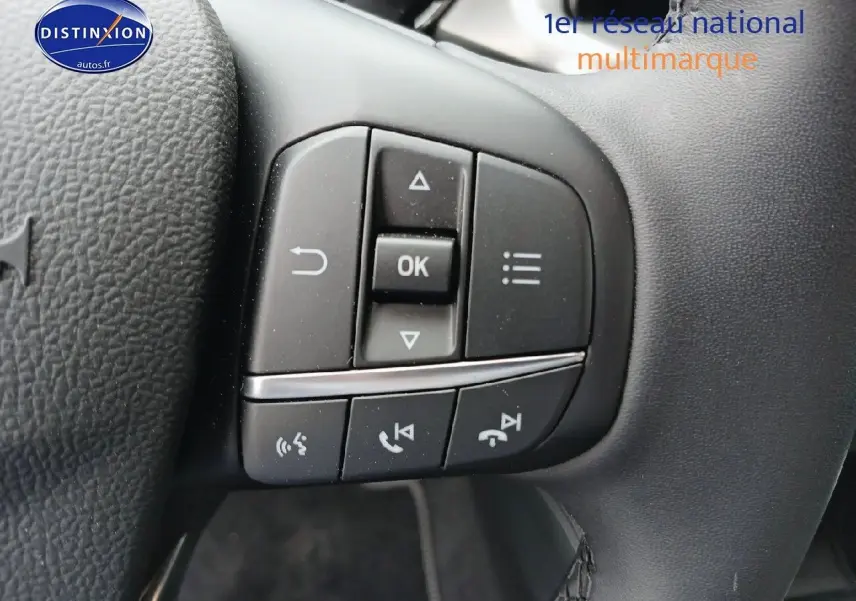 Gros plan sur les commandes multifonctions du volant cuir noir de la Ford Focus 2024 finition Titanium X Business.