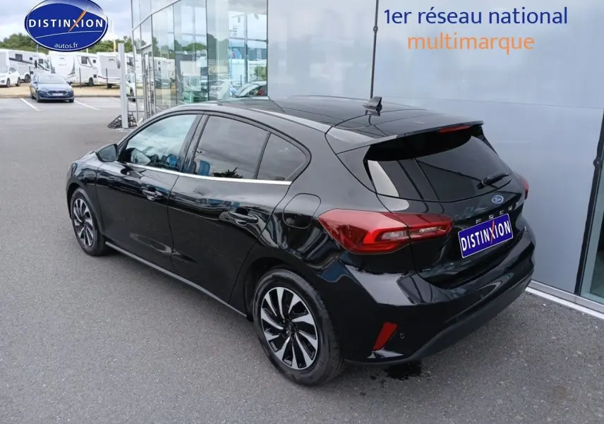 Ford Focus 2024 noir Agate métallisé vue 3/4 arrière côté gauche, avec vitres surteintées et jantes bicolores.