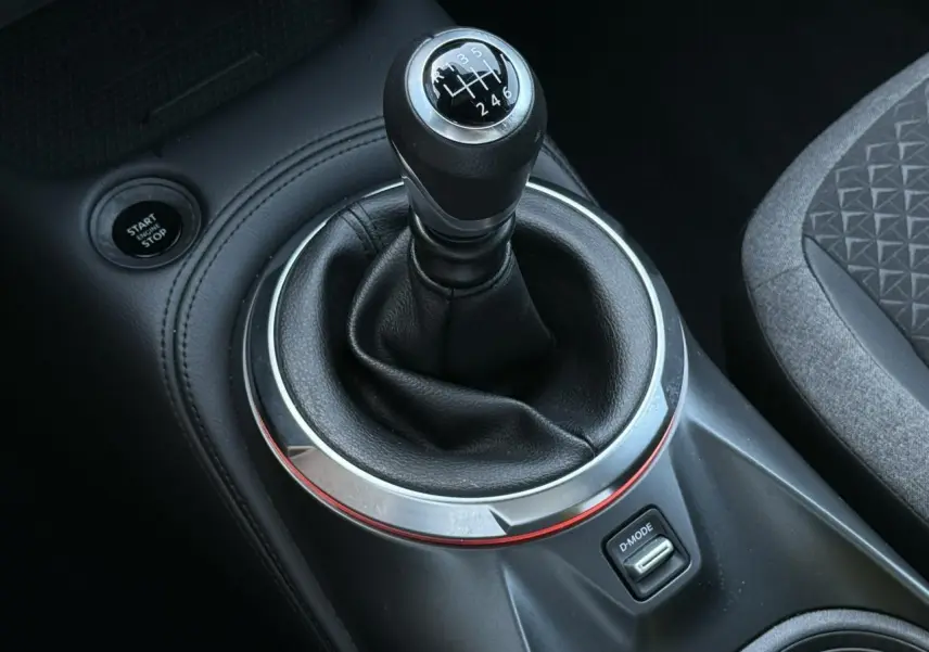 Gros plan sur le levier de vitesses manuel noir et argenté du Nissan Juke 2025 avec bouton Start/Stop et bouton D-Mode.