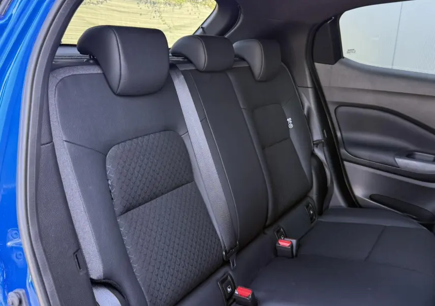 Vue intérieure sur la banquette arrière noire du Nissan Juke 2025, avec ceinture grise et sellerie mixte tissu/TEP.