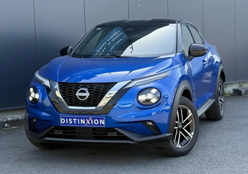 Nissan Juke 2025 bleu magnétique avec toit noir, vue 3/4 avant mettant en valeur ses phares LED ronds et jantes alliage.