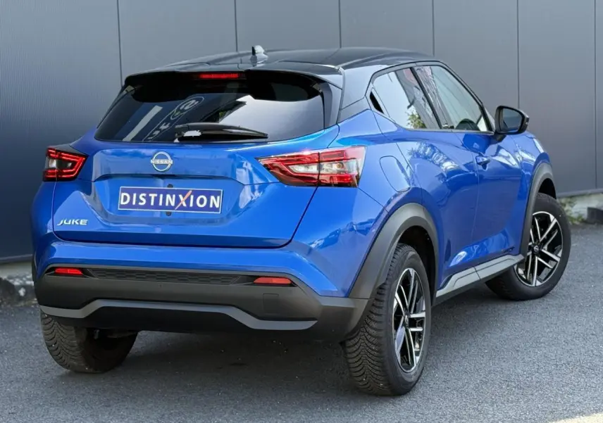 Vue 3/4 arrière droite du Nissan Juke 2025 bleu magnétique avec toit noir et jantes alliage 17 pouces.