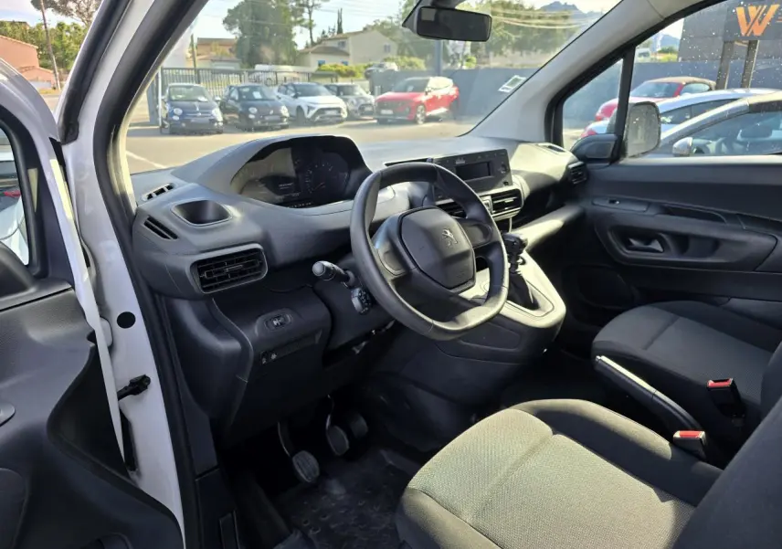 Intérieur du Peugeot Rifter blanc, vue côté conducteur, volant compact et tableau de bord avec écran central.