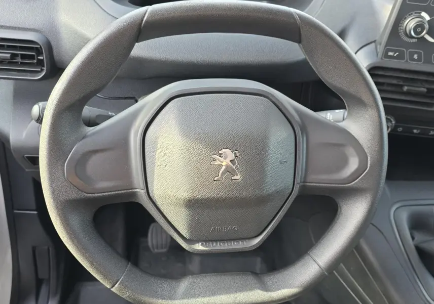 Vue rapprochée du volant noir Peugeot au design compact dans l'habitacle du Rifter 1.5 BlueHDi 2021.