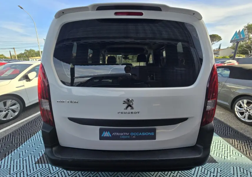 Vue arrière d'un Peugeot Rifter blanc Banquise 2021 avec hayon vitré et pare-chocs noir mat visible en extérieur.