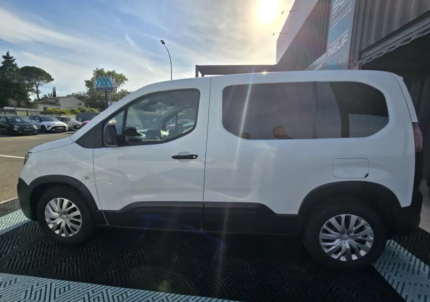 Peugeot Rifter blanc banquise vu de profil côté gauche, avec vitres arrière teintées et jantes tôle argentées.