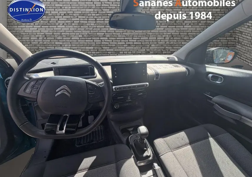 Vue intérieure avant de la Citroën C4 Cactus 2020, volant cuir, levier manuel, sellerie tissu gris, tableau de bord moderne.