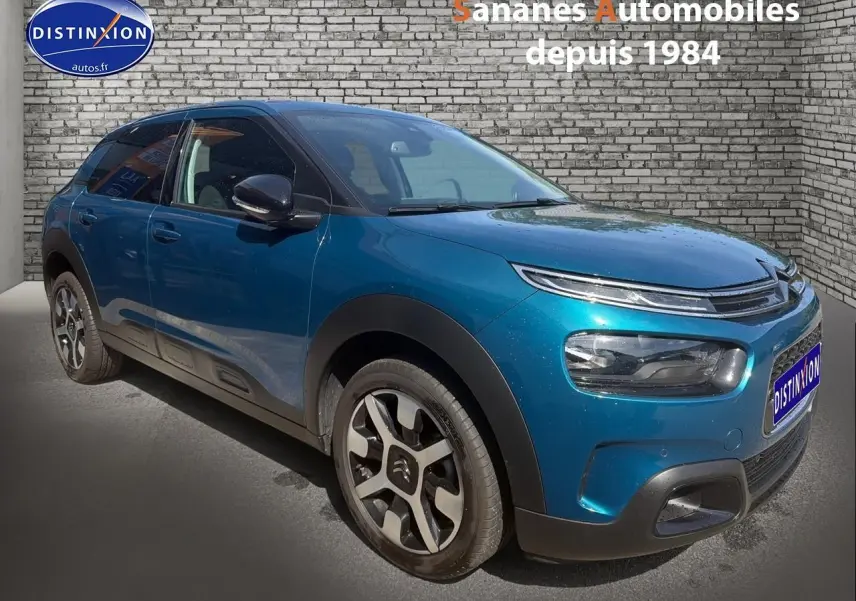 Citroën C4 Cactus bleu métal en 3/4 avant droit, avec jantes alliage et protections noires sur carrosserie.