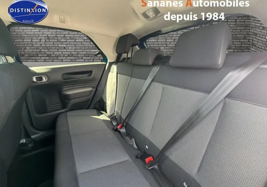 Vue intérieure des sièges arrière en tissu gris de la Citroën C4 Cactus, côté gauche, avec ceintures attachées.