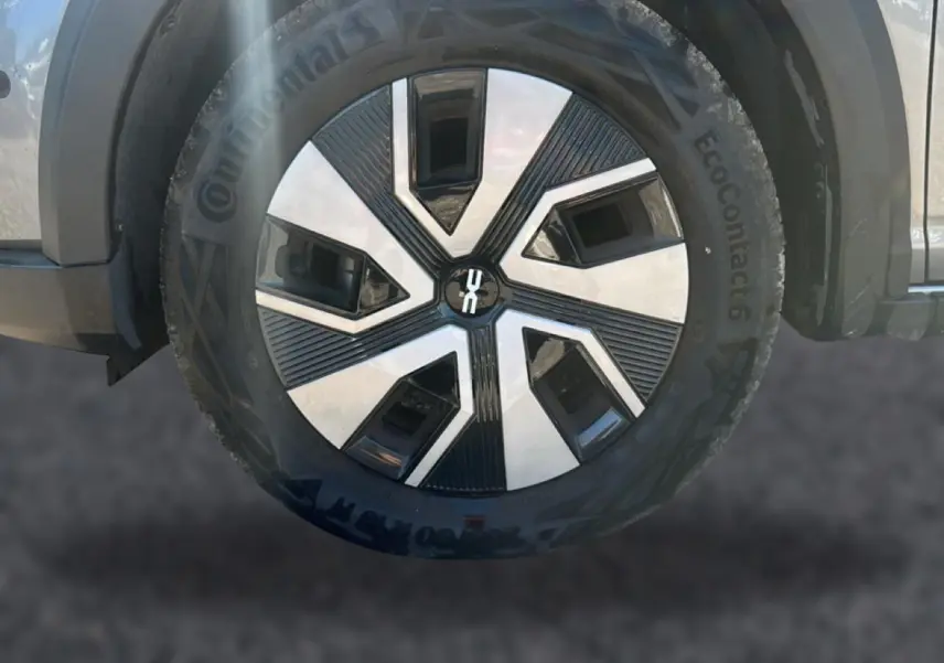 Gros plan sur la roue avant droite d'une Dacia Sandero gris schiste avec jante alliage au design géométrique.