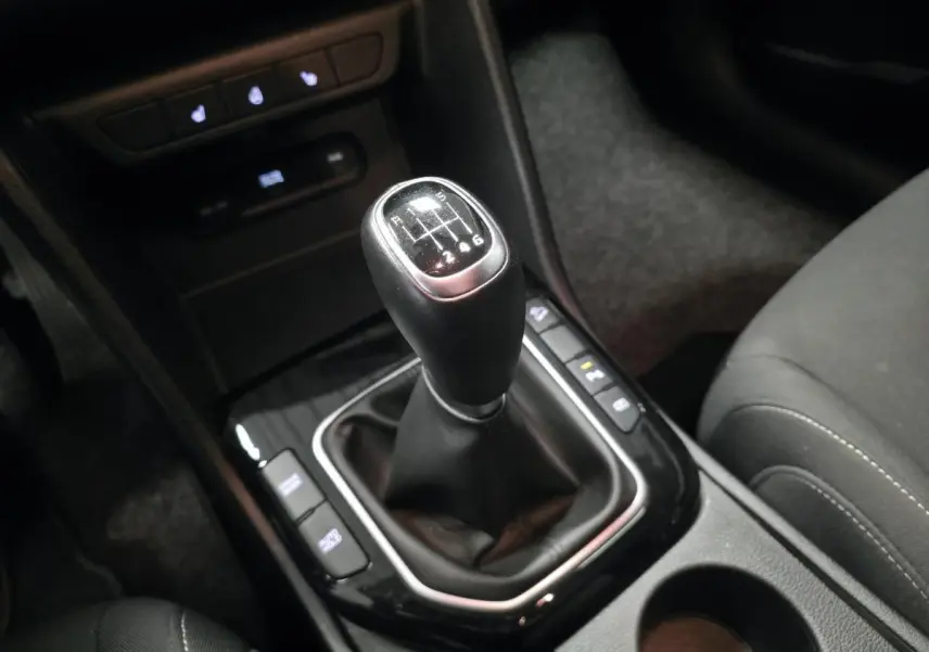 Le levier de vitesses manuel noir du Kia Sportage 2022, vu en gros plan depuis le siège conducteur.