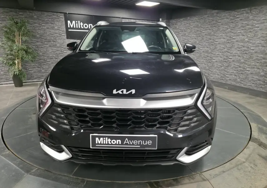 Vue frontale d'un Kia Sportage noir 2022 avec calandre noire laquée et inserts argentés sur boucliers.