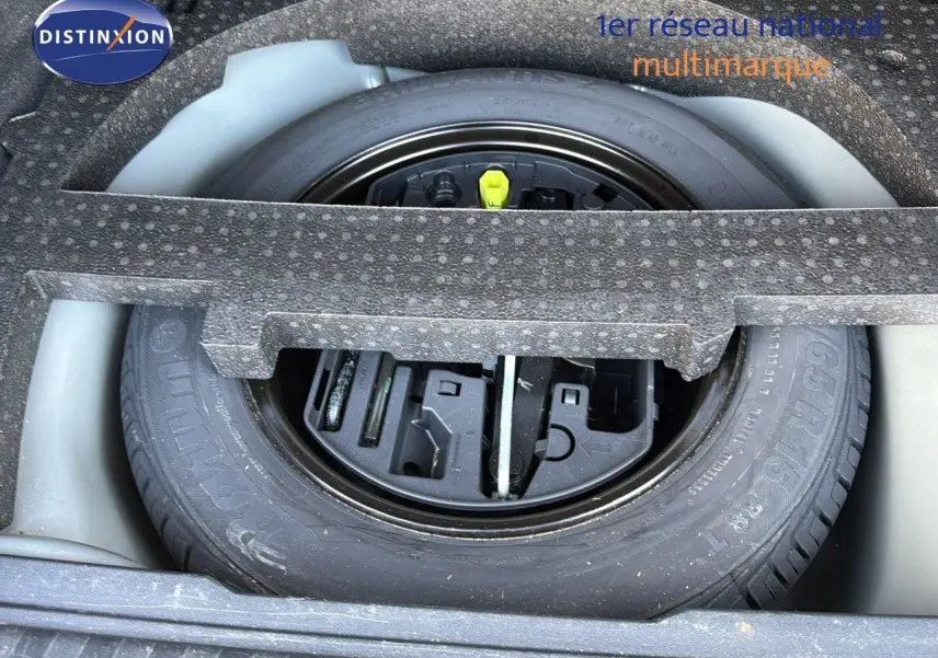 Roue de secours et kit de réparation logés dans le coffre d'une Peugeot 2008 gris platinium vue de dessus.