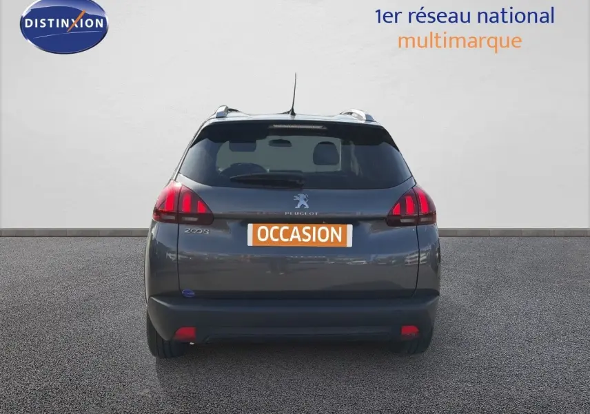 Vue arrière d'un Peugeot 2008 gris platinium de 2019 avec feux rouges et toit équipé de barres de toit.