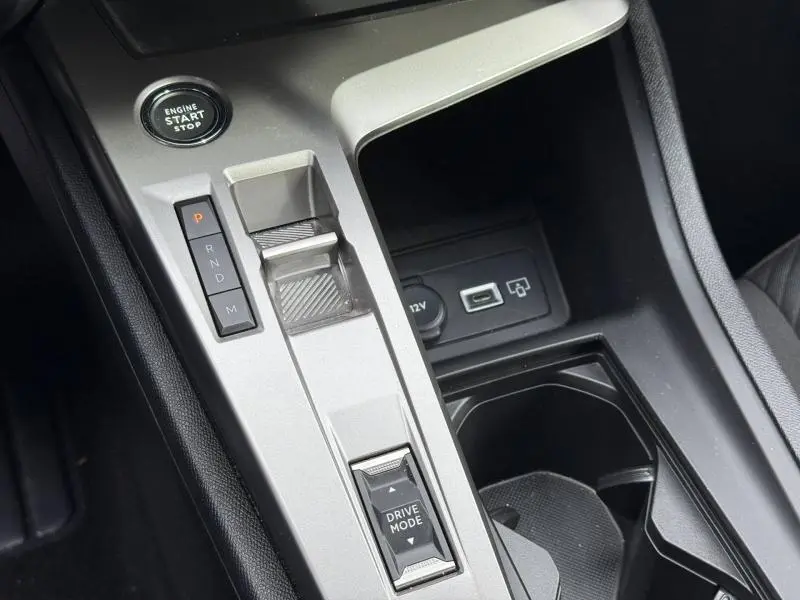 Vue rapprochée de la console centrale argentée de la Peugeot 308 2024 avec bouton start, sélecteur de boîte auto et prise USB.