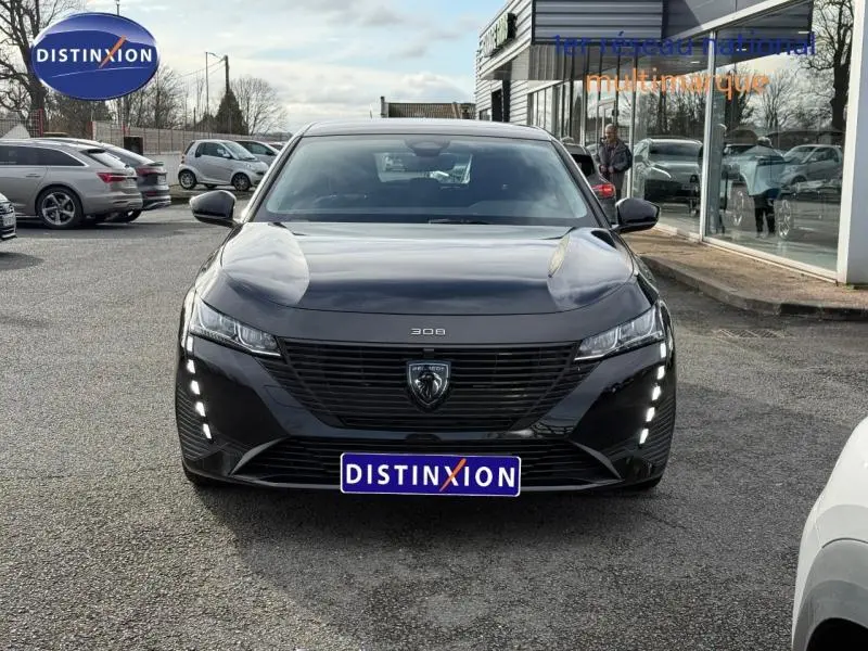 Vue frontale d'une Peugeot 308 2024 noire Perla Nera avec feux LED verticaux et calandre noire distinctive.