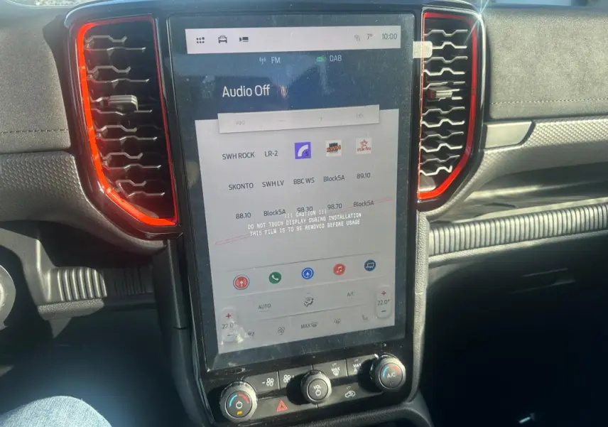 Vue rapprochée de l’écran tactile central du Ford Ranger Raptor 2025 blanc, avec cadre noir et contours rouges.