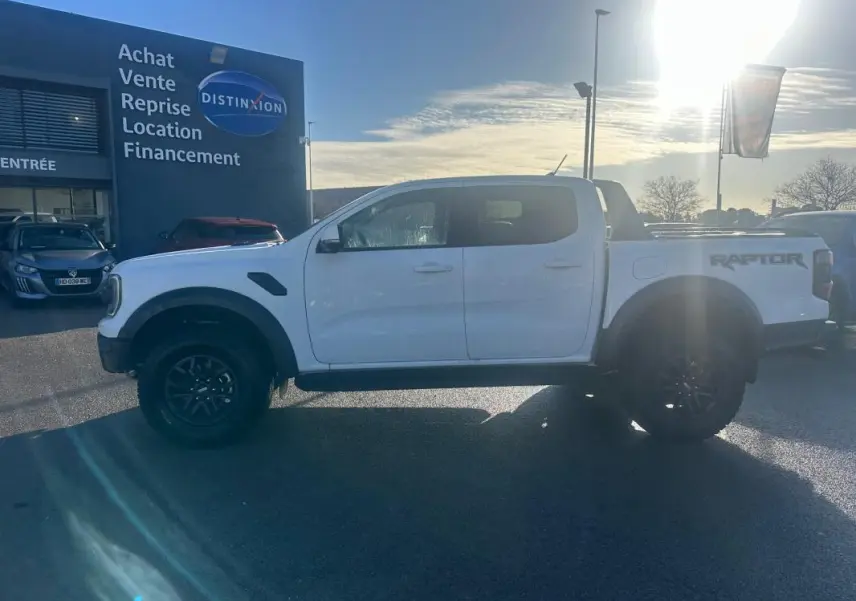 Ford Ranger Raptor blanc en profil gauche, avec jantes alliage noires et marquage RAPTOR sur la benne.