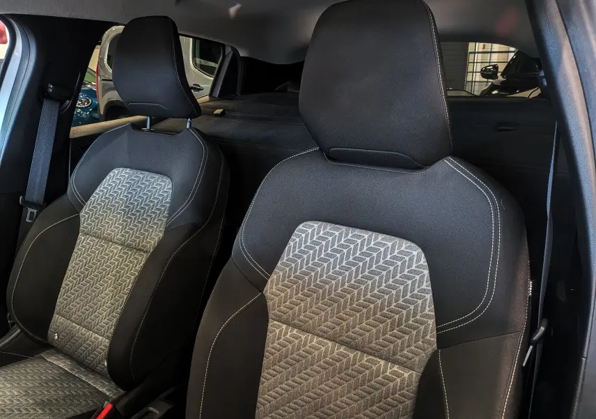 Gros plan sur les sièges avant en tissu noir et gris à motifs géométriques de la Renault Clio V Société Gris Platine.