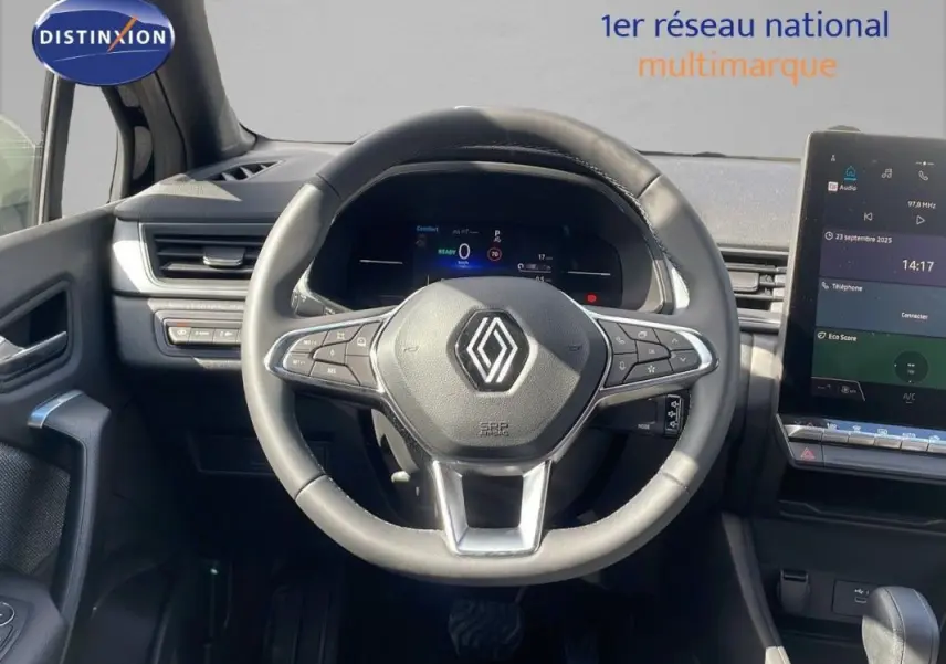 Vue intérieure centrée sur le volant cuir et tableau de bord numérique du Renault Captur noir 2025, avec écran tactile visible.