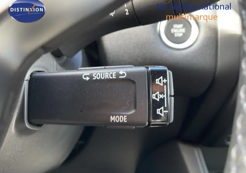Gros plan sur la commande au volant noir du Renault Captur 2025, avec bouton source et mode visibles.