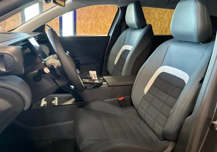 Vue intérieure côté conducteur du Citroën C5 Aircross 1.2 hybride 2026, sièges tissu noir avec inserts gris clair.