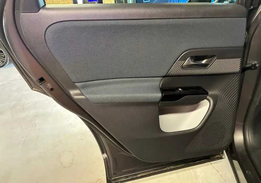 Vue rapprochée de la porte arrière gauche grise du Citroën C5 Aircross 1.2 Hybride 2026, avec insert texturé noir et tissu gris.