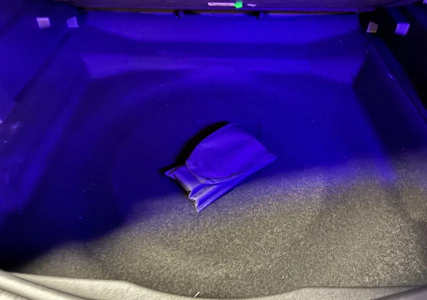 Coffre du Citroën C5 Aircross gris 2026 éclairé en bleu, montrant un rangement central avec pochette.