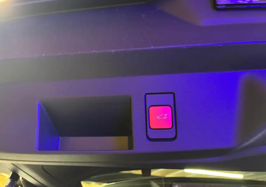Bouton rouge d'ouverture électrique du hayon sur la garniture intérieure d'un Citroën C5 Aircross gris hybride 2026.