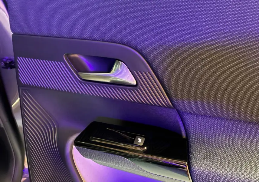 Détail de la porte intérieure côté gauche du Citroën C5 Aircross gris 2026, avec poignée argentée et commande de vitre.