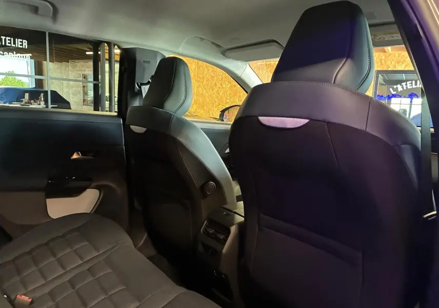 Vue intérieure arrière du Citroën C5 Aircross gris, mettant en valeur les sièges en tissu noir et l'espace aux jambes.