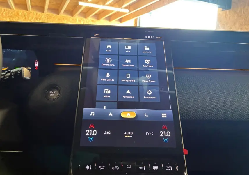Vue rapprochée de l’écran tactile central du tableau de bord du Citroën C5 Aircross gris, affichant les commandes multimédia et climatisation.