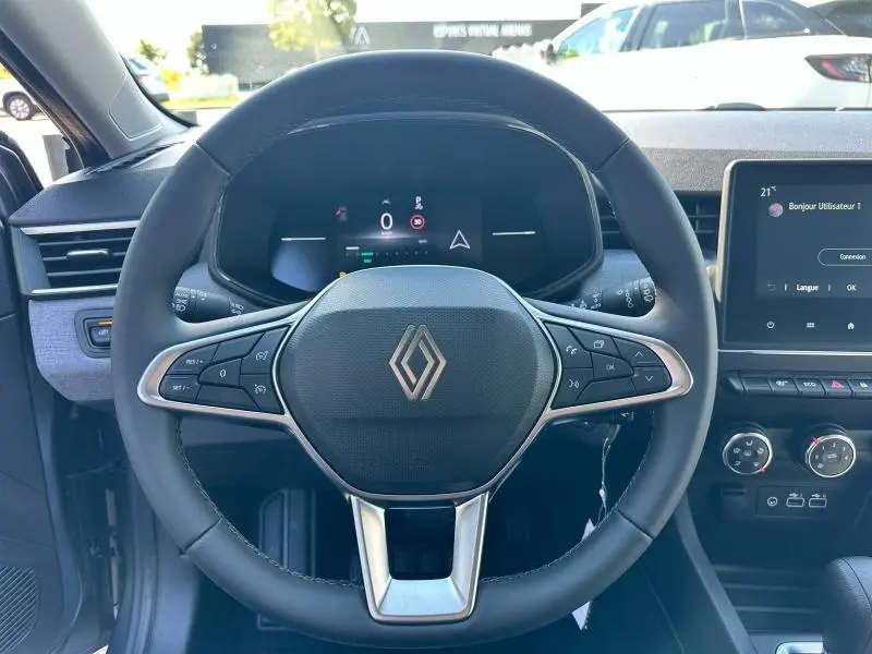 Vue frontale du volant noir de la Renault Clio 2025 avec tableau de bord numérique et écran tactile central.