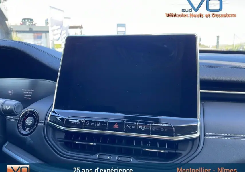 Écran tactile central et tableau de bord noir du Jeep Compass blanc 2024 vue intérieure avant.