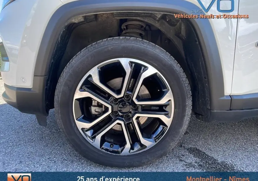 Gros plan sur la jante alliage 18 pouces noire et argent du côté avant gauche d’un Jeep Compass blanc 2024.