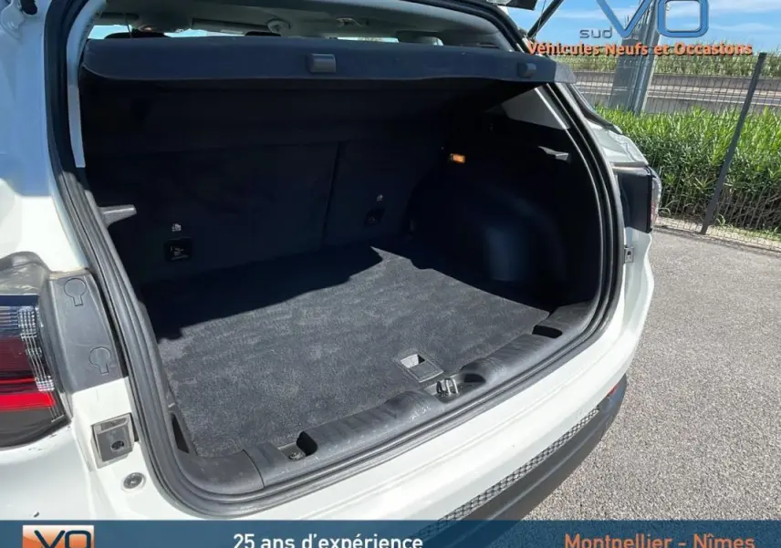 Coffre ouvert du Jeep Compass blanc 2024 vu de l'arrière droit, montrant un espace de chargement propre et spacieux.