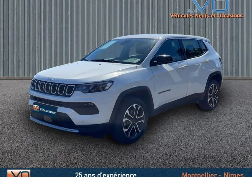 Jeep Compass blanc vue 3/4 avant droit, jantes alliage 18 pouces et rétroviseurs noirs sur fond urbain.