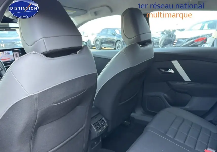 Vue intérieure arrière de la Citroën C4 électrique 2025 gris foncé, montrant les sièges et la console centrale.