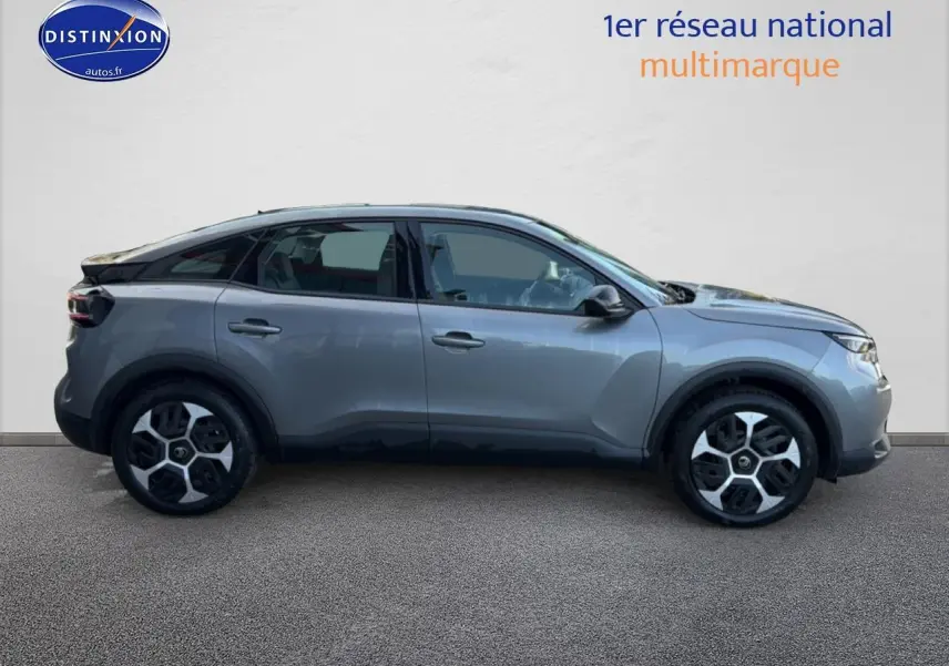 Vue latérale droite d'une Citroën C4 électrique 2025 gris foncé avec jantes distinctives et lignes modernes.