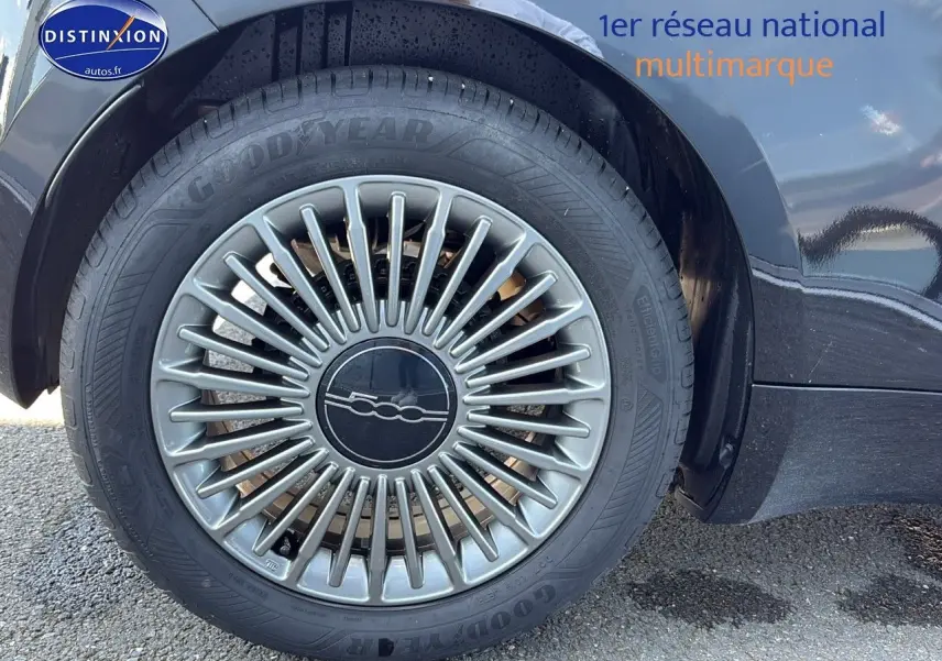 Gros plan sur la roue avant droite de la FIAT 500 électrique 2024, jante alu au design étoilé gris.
