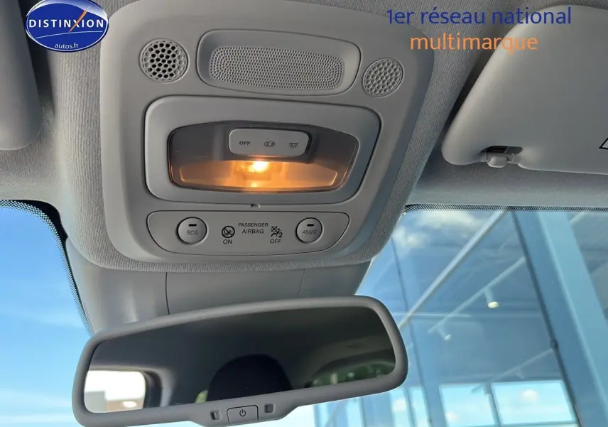 Vue intérieure centrée sur le plafonnier et le rétroviseur intérieur d'une Fiat 500 électrique blanche 2024.