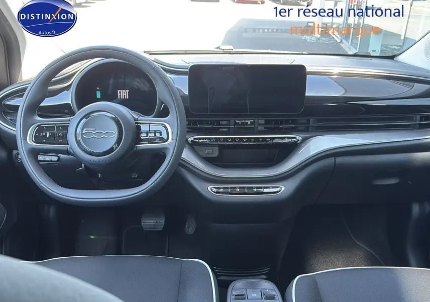 Vue intérieure avant du tableau de bord noir et volant multifonction de la Fiat 500 électrique blanche 2024.