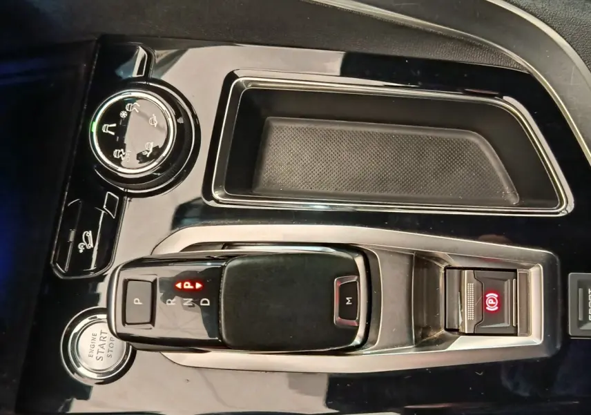 Gros plan sur la console centrale noire brillante du Peugeot 5008 2019, avec levier de vitesse automatique et bouton start/stop.