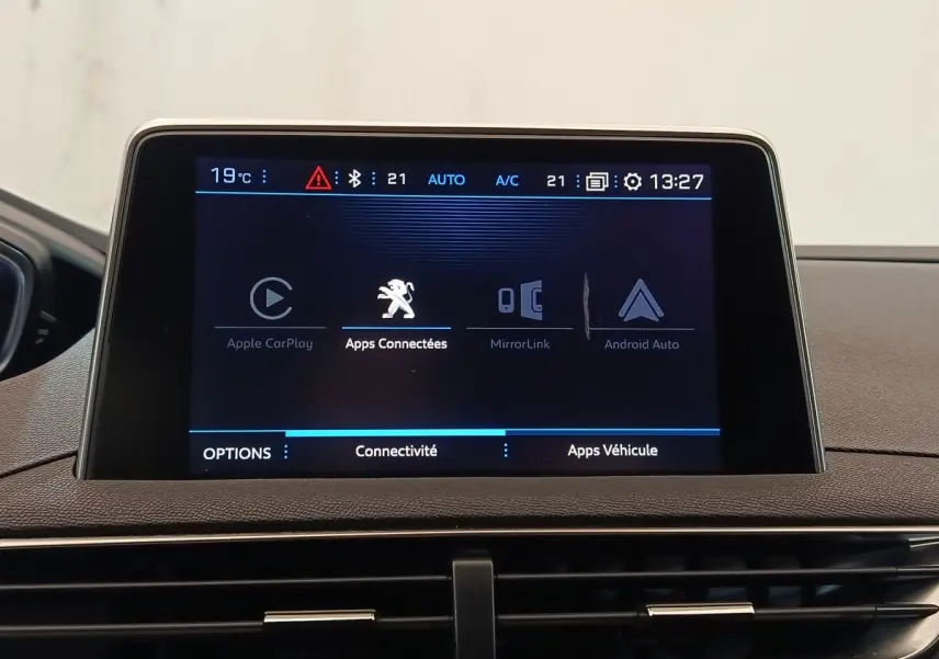 Écran tactile central du tableau de bord du Peugeot 5008 gris clair, affichant les options de connectivité.