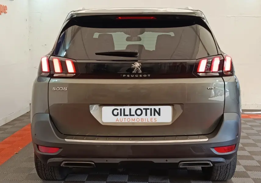 Vue arrière d'un Peugeot 5008 gris clair version GT avec feux LED distinctifs et double sortie d'échappement.